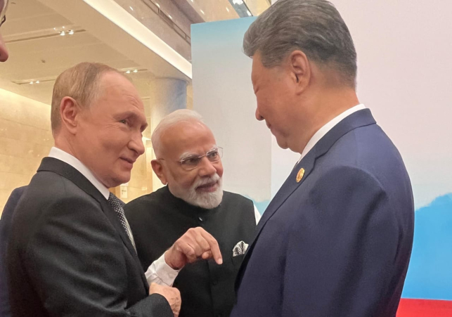 Russian President Vladimir Putin, Chinese President Xi Jinping, and Indian Prime Minister Narendra Modi join hands in a unity gesture during talks on economic cooperation and multipolar world order.